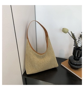 Close-up of woven hobo tote bag featuring beige texture and brown leather trim details