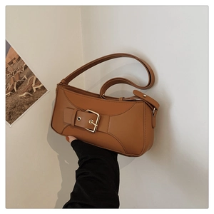 Detail of caramel leather crossbody bag with golden square buckle and adjustable strap