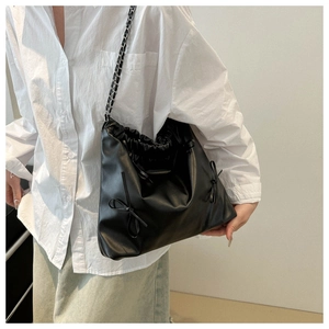 Détail du sac cabas plissé noir avec fermeture à cordon et bandoulière en chaîne