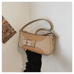 Detailed close-up of a vintage contrast patchwork baguette bag with gold buckle detail