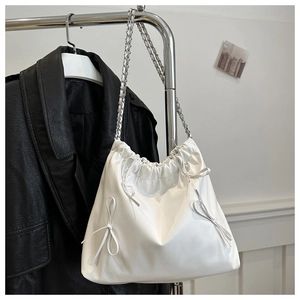 Détail du sac plissé blanc avec fermeture à cordon et petits nœuds décoratifs