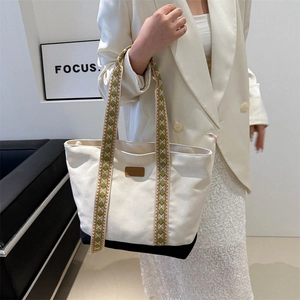 Grand sac cabas en toile beige avec base noire et bandoulière tissée géométrique