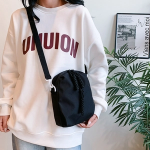 Black nylon crossbody bag with woven rope detail and white buckle for casual style
