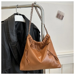Détail d'un sac cabas marron plissé en cuir PU avec nœuds et bandoulière chaîne