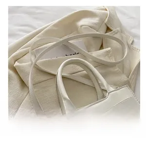 Dettaglio del fiocco bianco con strass a cuore su una borsa a tracolla alla moda