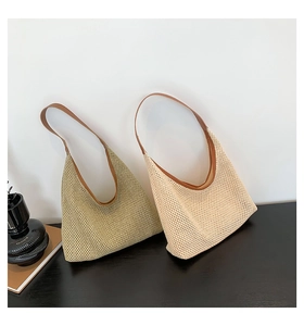 Detail of woven mesh shoulder bag texture in olive green and cream with leather straps