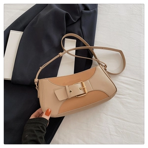 Detail of beige and camel patchwork underarm bag with decorative metal buckle and strap
