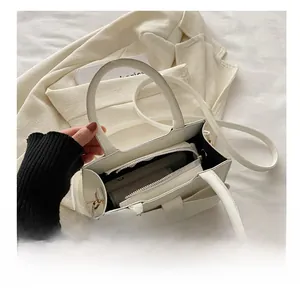 Dettaglio interno della borsa a fiocco bianco crema con pratiche tasche con cerniera