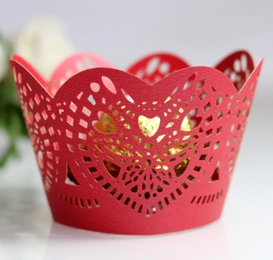 Detailed laser-cut heart pattern on red cupcake wrapper with intricate lace hollow design