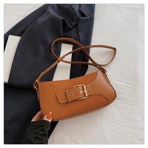Detail of vintage brown leather bag featuring adjustable strap and metallic gold buckle