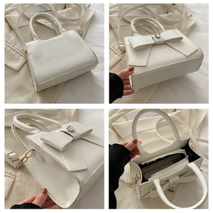 Dettaglio della borsa beige con grande fiocco e strass a forma di cuore scintillante