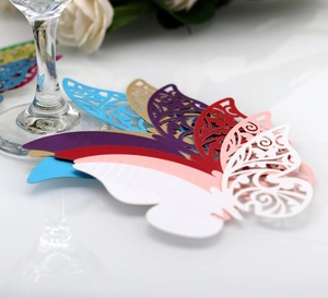 Detail view of laser-cut 3D butterfly glass cards in assorted colors for wedding decor