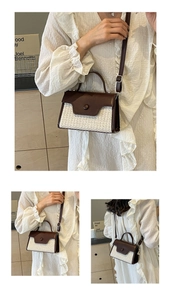 Detail of woven straw and brown leather crossbody bag with rounded button closure
