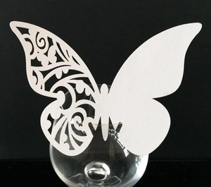Gros plan de la carte de verre papillon blanc découpée au laser pour les mariages