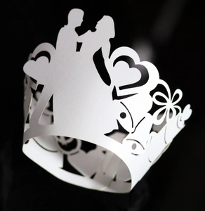 Detailed laser-cut wedding cupcake wrapper featuring bride and groom silhouettes in white