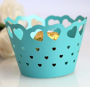 Macro detail of laser-cut heart pattern on blue wedding cupcake paper wrapper
