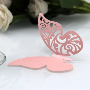 Vue macro d'un marque-place papillon rose découpé au laser pour décoration de mariage