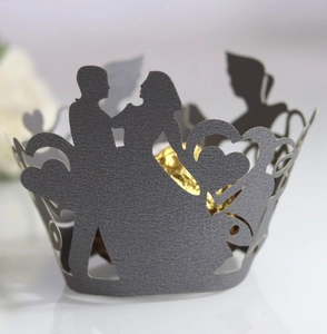Laser-cut cupcake wrapper with bride and groom silhouette and hollow heart detail