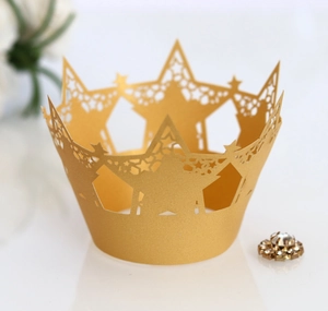 Golden laser-cut star pattern cupcake wrappers with sparkling rhinestone decoration