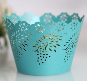 Detail of mint green laser-cut cupcake wrapper featuring an intricate grape pattern design