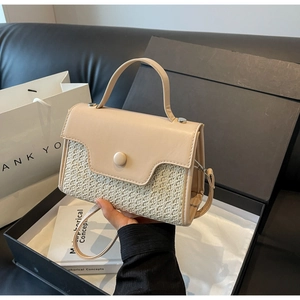 Detail of beige woven panel and smooth leather texture on an elegant crossbody bag