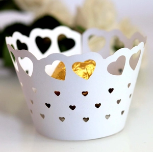 Macro detail of laser-cut heart pattern cupcake wrapper with gold chocolate accent