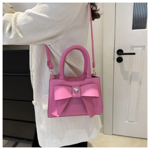 Dettaglio borsa rosa con grande fiocco e charm a forma di cuore con strass luminosi