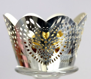 Detail view of silver laser-cut cupcake wrapper with heart patterns and gold foil chocolate