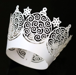 Macro view of white pearlescent cupcake wrappers with laser-cut snowflake patterns