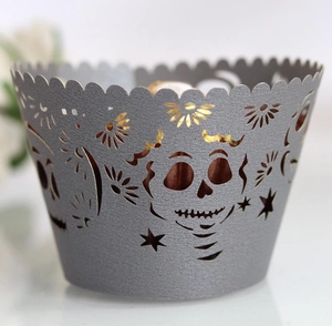 Macro shot of laser-cut skull and star pattern on silver hollow cupcake wrappers