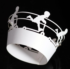 Detail showing white laser-cut cupcake wrappers with scooter silhouettes on black background