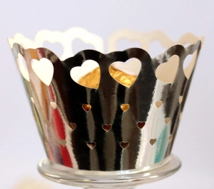 Macro shot of silver laser cut heart cupcake wrapper with a golden chocolate ball
