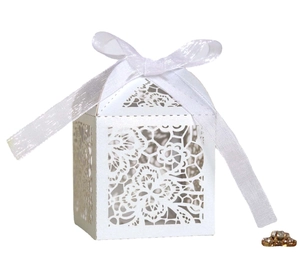Detail of laser-cut floral pattern and white satin ribbon on wedding favor box