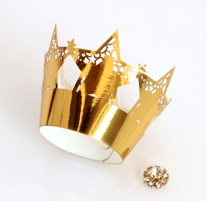 Macro shot of gold laser-cut cupcake wrappers with star pattern and rhinestone detail