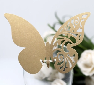 Close-up of gold butterfly place card with hollow pattern on a glass rim decoration