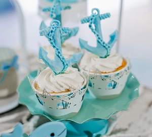Detailed close-up of nautical laser-cut cake wrappers and anchor toppers for weddings
