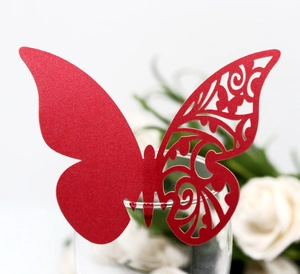 Detail of red butterfly place card with laser-cut lace pattern on a glass rim