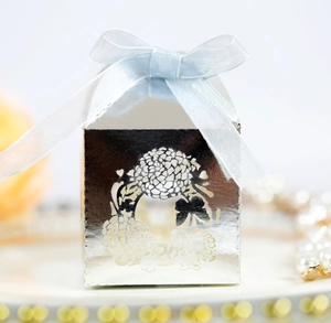 Close-up of hollow flower pattern on silver gift box with a blue silk ribbon bow