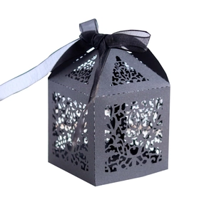 Close-up of laser-cut European floral patterns and satin ribbon on black candy box