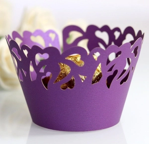 Macro detail of purple laser-cut heart cupcake wrapper with intricate lace design