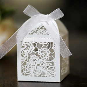 White laser cut wedding favor box with floral patterns and a white organza ribbon