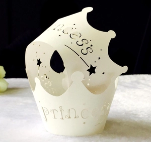 Macro view of laser-cut crown cupcake wrapper with Princess text and star hollows