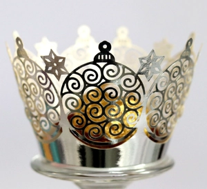 Detail of silver laser-cut crown cupcake wrappers with festive snowflake patterns