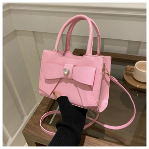 Dettaglio borsa rosa con fiocco decorativo, cristallo a cuore e manico arrotondato