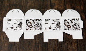 Détail de boîte cadeau en papier découpé au laser avec fleurs et silhouette de visage