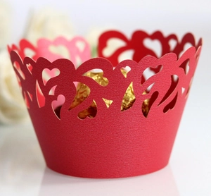 Detailed view of red laser-cut cupcake liner with heart pattern and gold chocolate