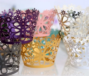 Laser cut floral cupcake wrappers in various pearlescent colors for wedding cake decoration