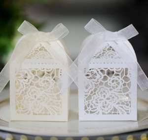 Detailed laser-cut floral pattern on wedding candy box with elegant ribbon bow decoration