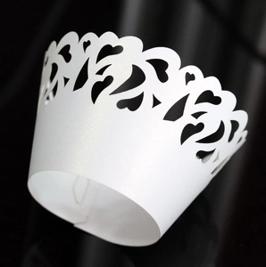 Macro detail of laser-cut heart pattern cupcake wrapper with white pearlescent finish