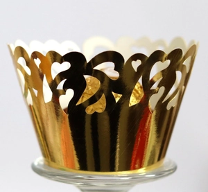 Macro view of gold laser-cut heart cupcake wrapper with chocolate for party